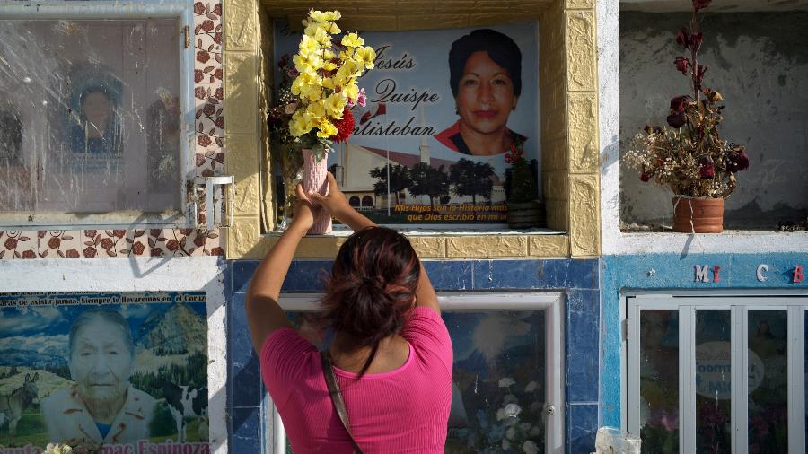 Hellen Ñañez, que perdeu 13 familiares para a covid-19, visita túmulo de tia em cemitério de Pisco, no Peru - Alessandro Cinque/Reuters