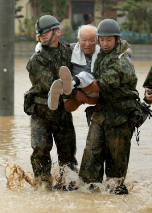 Soldados ajudam morador local a deixar área alagada na cidade de Fukuoka - Jiji Press/AFP Photo