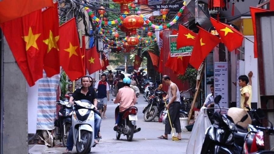 Bandeiras vermelhas e lanternas são destaque em festia no bairro antigo de Hanói, no Vietnã - Hoang Dinh/AFP