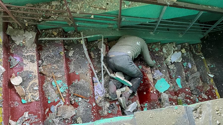 2.jun.2022 - Corpo de civil foi encontrado em escada de prédio de escola que foi atingida por ataque em Kharkiv, no leste da Ucrânia - Vitalii Hnidyi/Reuters