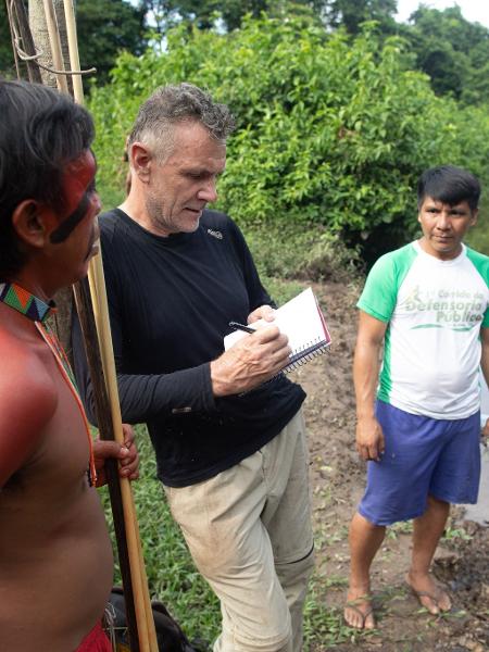 16.nov.2019 - O jornalista Dom Phillips (c) conversa com indígenas da aldeia Maloca Papiú, no Roraima - JOAO LAET/AFP