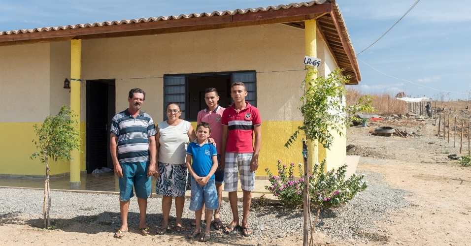 31.jan.2017 - Deslocados pela transposição, o agricultor Edval Pereira Lins (à esquerda) e a família, em frente à casa onde foram reassentados, na VPR Cacaré (PB)