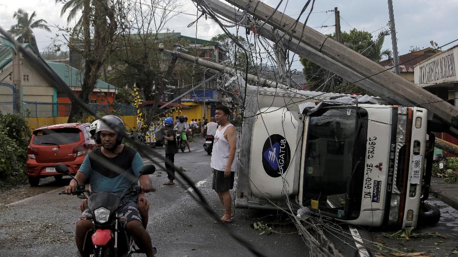 3.dez.2019 - Tufão Kammuri derrubou postes e virou carros na cidade de Camalig, nas Filipinas - Reuters
