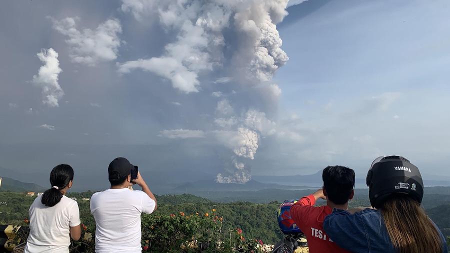 Pessoas tiram fotos de uma explosão do vulcão Taal, vista da cidade de Tagaytay, na província de Cavite, a sudoeste de Manila - Bullit MARQUEZ / AFP