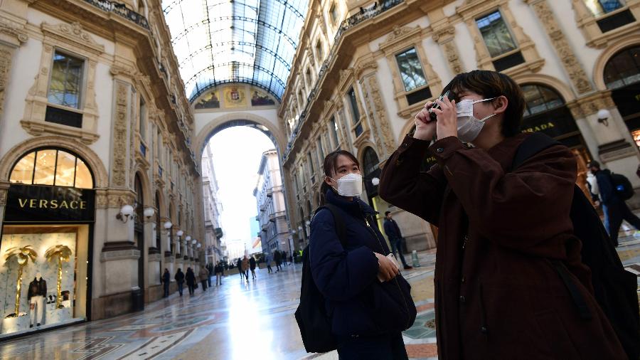 28.fev.2020 - Turistas usam máscaras de proteção na Galleria Vittorio Emanuele 2º, um dos principais pontos turísticos de Milão - Miguel Medina/AFP
