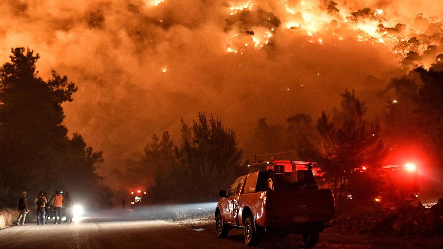 As chamas aumentam enquanto bombeiros e voluntários tentam apagar um incêndio na aldeia de Schinos, perto de Corinto, Grécia - REUTERS / Vassilis Psomas TPX 