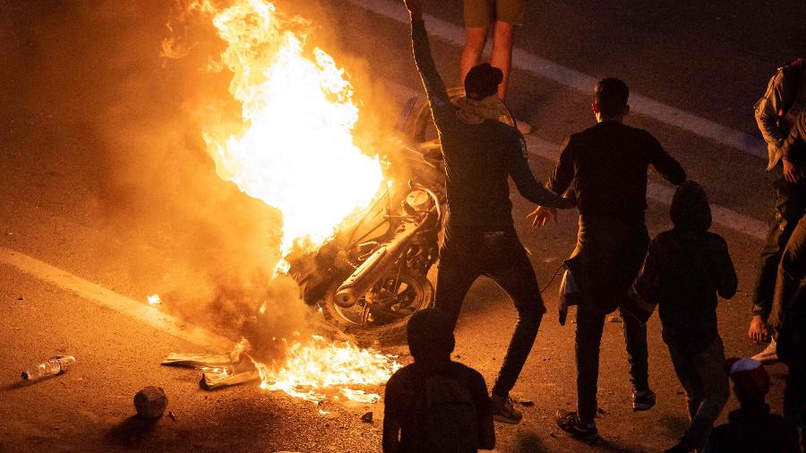 Migrantes queimam uma motocicleta em protesto por serem parados pela polícia marroquina ao cruzarem a fronteira - AFP/Fadel Senna