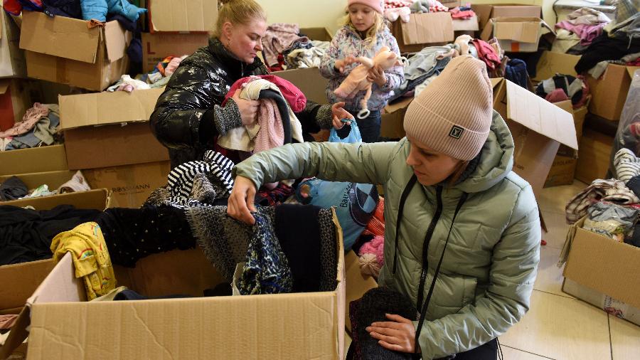 11.abr.22 - Ucranianos deslocados recolhem roupas doadas em um ponto de coleta de ajuda na cidade ocidental de Lviv no 47º dia da invasão russa da Ucrânia - YURIY DYACHYSHYN/AFP
