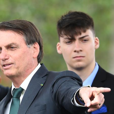 Jair Bolsonaro e o filho (ao fundo) que usará seu nome nas eleições deste ano