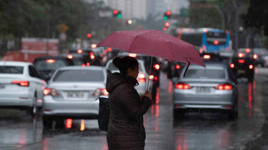 Pessoas se protegem da chuva em meio ao trânsito  - Bruno Rocha/FotoArena/Estadão Conteúdo