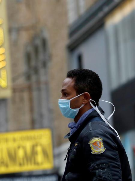 12.mar.2020 - Homem usando máscara caminha pela Broadway após anúncio de cancelamentos por causa do coronavírus - Andrew Kelly/Reuters