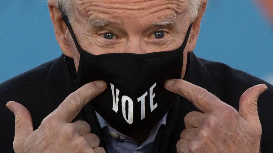 4.jan.2021 - O presidente eleito dos Estados Unidos, Joe Biden, aponta para máscara onde se lê a palavra "vote" durante comício em Atlanta, na Geórgia - Jim Watson/AFP