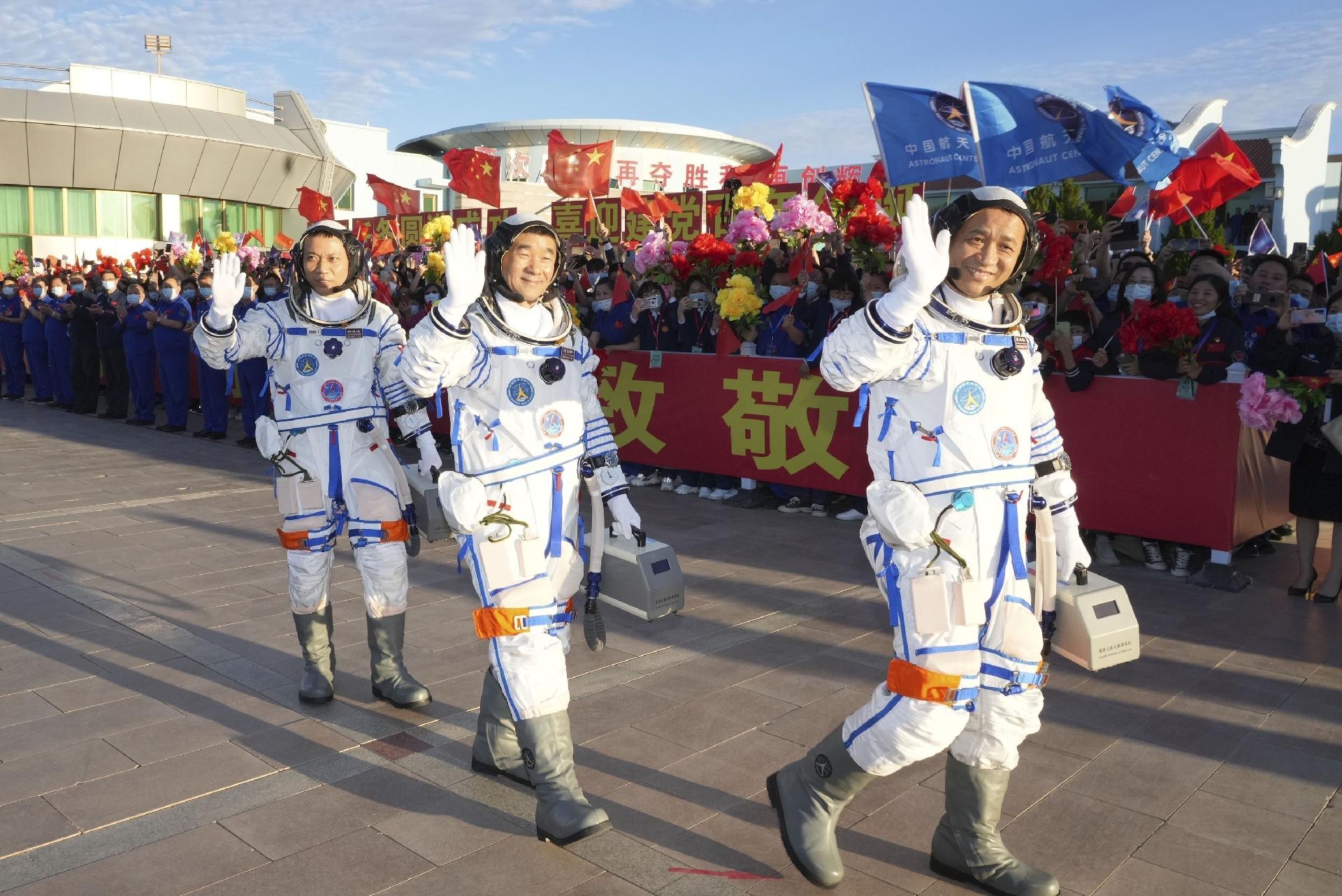 Os astronautas Nie Haisheng, Liu Boming e Tang Hongbo acenam durante cerimônia antes do lançamento da missão espacial tripulada Shenzhou-12, no Centro de Lançamento de Satélites de Jiuquan, no noroeste da China, em 17 de junho de 2021 - Xinhua/Li Gang