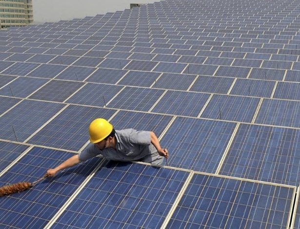 Funcionário limpa painéis de energia solar na China; governo do país está subsidiando produtores de energia renovável - REUTERS