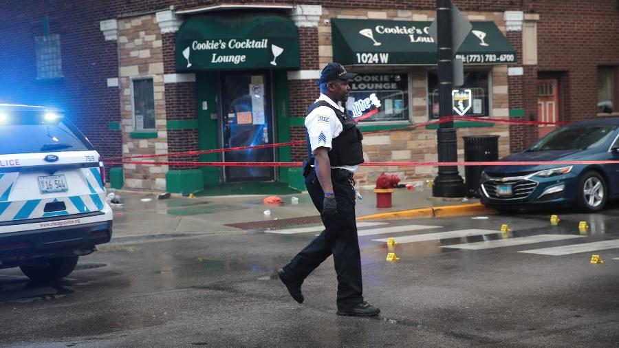 Policiais isolam área para analisar local alvo dos disparos que deixaram 14 pessoas feridas em funeral nos EUA - Scott Olson/Getty Images/AFP