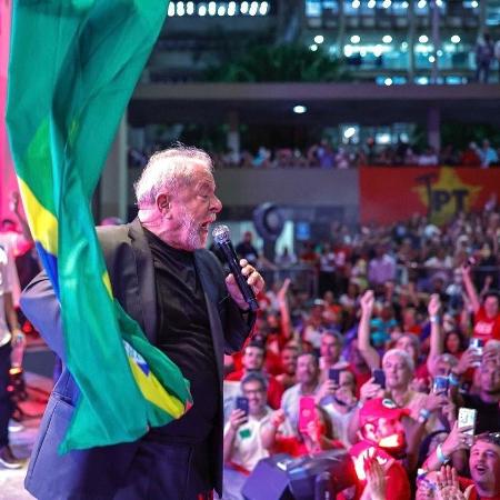 30.mar.2022 - O ex-presidente Lula exibe bandeira do Brasil durante discurso em evento na Uerj - Ricardo Stuckert/ Divulgação