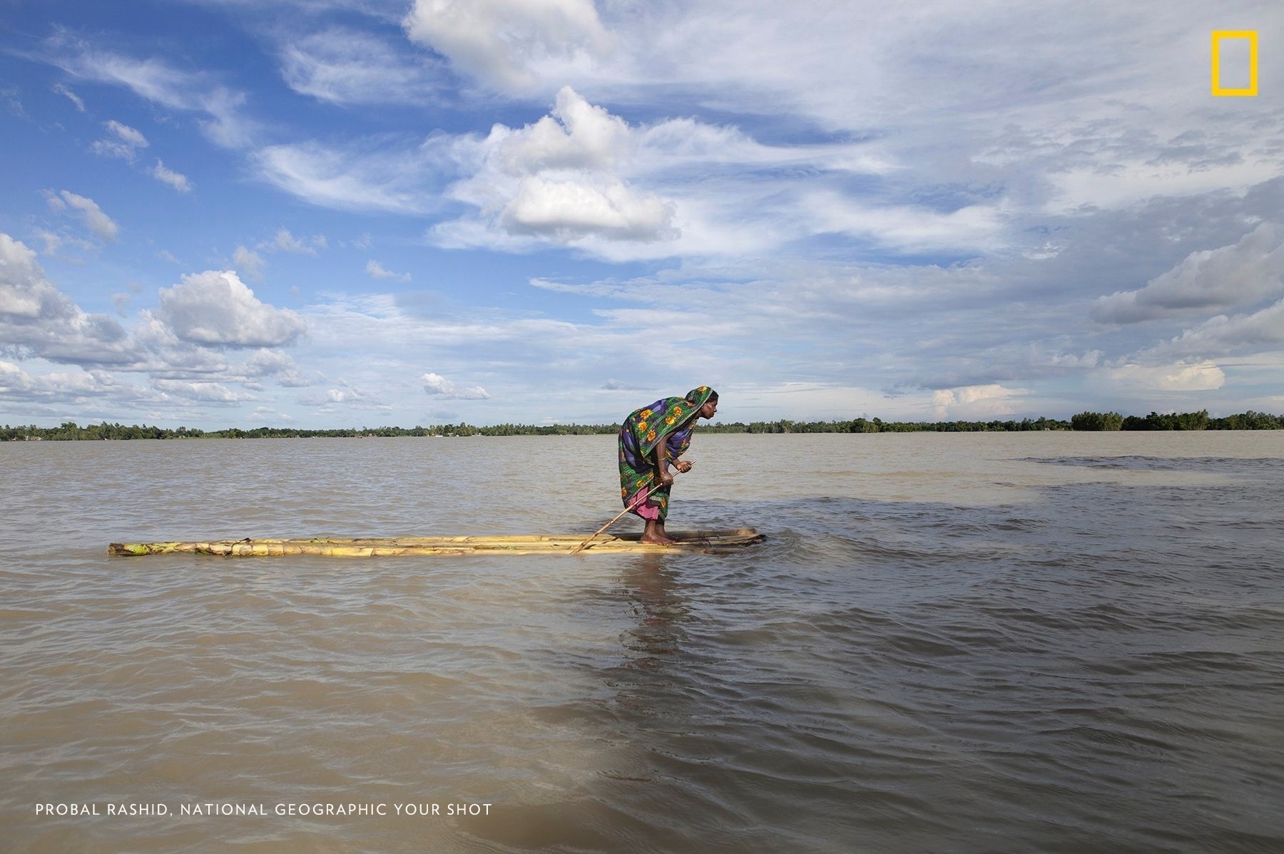 Em Bangladesh, uma mulher afetada por uma enchente utiliza uma espécie de canoa para chegar a algum local seco para se abrigar. A diretora do programa "Your Shot" da National Geographic. Monica Corcoran, diz que a foto tem uma "qualidade épica e fala de algo maior do que ela mostra" - Probal Rashid/National Geographic Your Shot