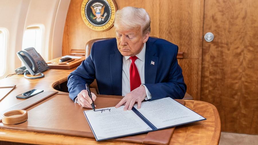 14.mai.2020 - O presidente dos Estados Unidos (EUA), Donald Trump, assina documento a bordo do Air Force One - Shealah Craighead/White House