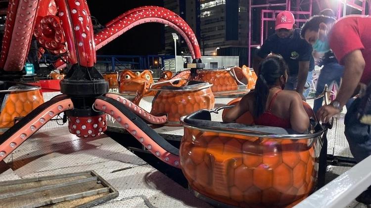 Pessoas vão sentadas nas cabines, suspensas pelo braço do polvo - Reprodução/Praia Grande Mil Grau - Reprodução/Praia Grande Mil Grau