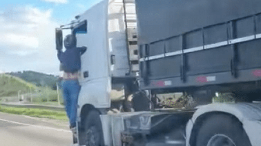 Vídeos publicados nas redes sociais mostram o motociclista pendurado do lado de fora da cabine do caminhão - Reprodução de vídeo