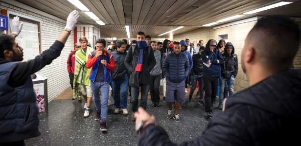 Voluntários direcionam refugiados que chegam à estação de trem de Dortmund, na Alemanha - Gordon Welters/The New York Times