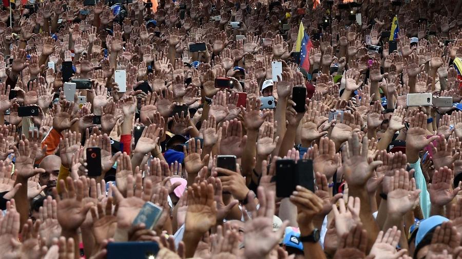 23.jan.2019 - Manifestantes erguem as mãos durante protesto contra o presidente Nicolás Maduro, na Venezuela - Federico Parra/AFP