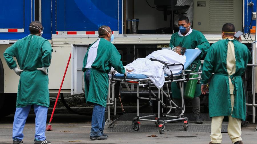 Funcionários do Hospital Estadual Anchieta, no Rio de Janeiro, empurram maca com paciente - WILTON JUNIOR/ESTADÃO CONTEÚDO