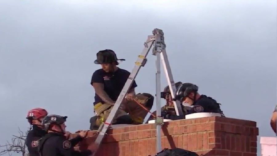 Imagem de bombeiros resgatando mulher presa em chaminé de cabeça para baixo - Reprodução