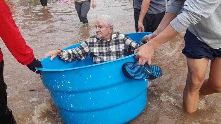 O aposentado Claro Neves, de 82 anos, em seu resgate dentro de uma caixa d'água na cidade de Canoas (RS); ele tem Alzheimer diagnosticado há 3 anos e estava na casa da filha, porque a casa dele ficou alagada até o telhado.