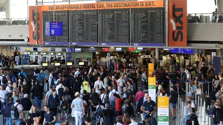 Passageiros fazem enormes filas no saguão do Aeroporto Internacional de Frankfurt, na Alemanha, depois que ativistas climáticos se colaram na pista e provocaram a suspensão de chegadas e partidas