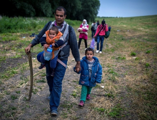 25.jun.2015 - Imigrantes sírios caminham na vila sérvia de Martonos em direção à fronteira com Hungria. O governo húngaro declarou que suspendeu por tempo indefinido o asilo de para imigrantes a fim de "proteger os interesses húngaros"