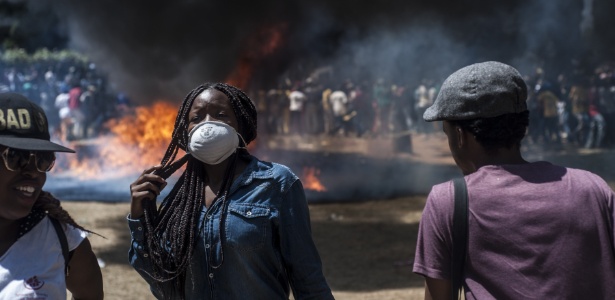 Estudante usa máscara para se proteger das bombas de gás durante um protesto na África do Sul  - Stefan Heunis/AFP