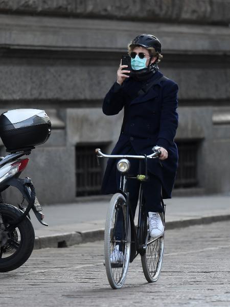 Homem pedala utilizando máscara de proteção para o coronavírus em Milão, na Itália - Xinhua