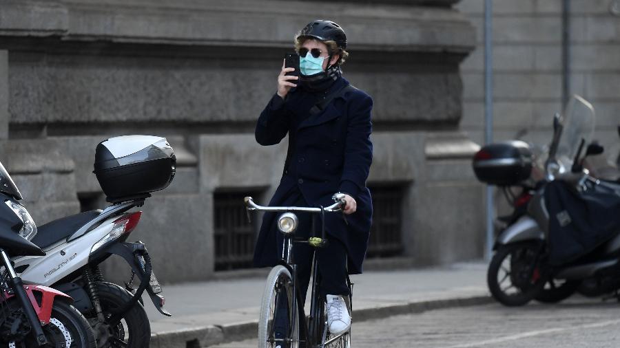 Homem pedala utilizando máscara de proteção para o coronavírus em Milão, na Itália - Xinhua