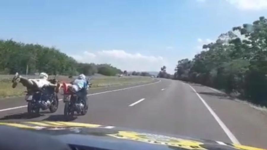 Motociclistas deitam sobre motos em rodovia - Divulgação/PRF