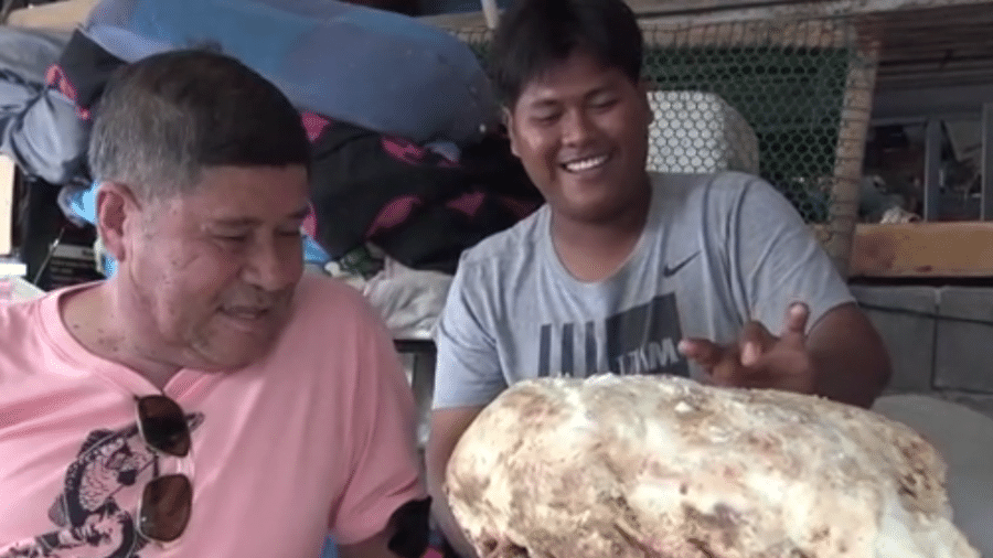 Mahapan sorri ao manusear o vômito de 7 kg, que deve lhe render uma fortuna - Reprodução/Daily Mail