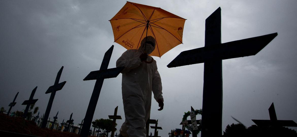 Funcionário passa por meio de sepulturas no cemitério Nossa Senhora Aparecida, em Manaus (AM) - Michel Dantas - 25.fev.21/AFP)