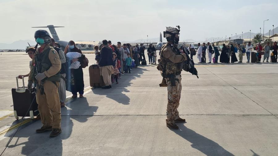 22.ago.2021 - Afegãos fazem fila antes de embarcar no avião militar italiano C130J, durante a evacuação no aeroporto de Cabul, no Afeganistão. - Ministério da Defesa Italiano/Folheto via REUTERS