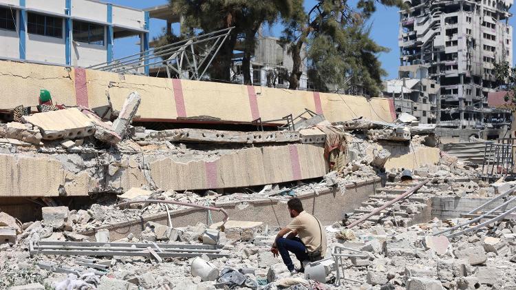 Morador observa destroços de escola atingida por Israel no centro da Cidade de Gaza, em 20 de agosto