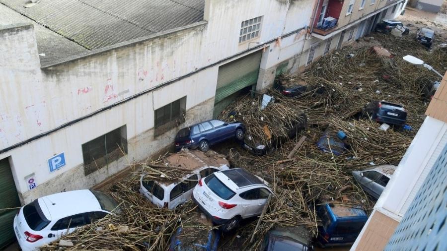 Uma foto tirada em Picanya, perto de Valência, leste da Espanha, em 30 de outubro de 2024, mostra carros empilhados em uma rua após enchentes