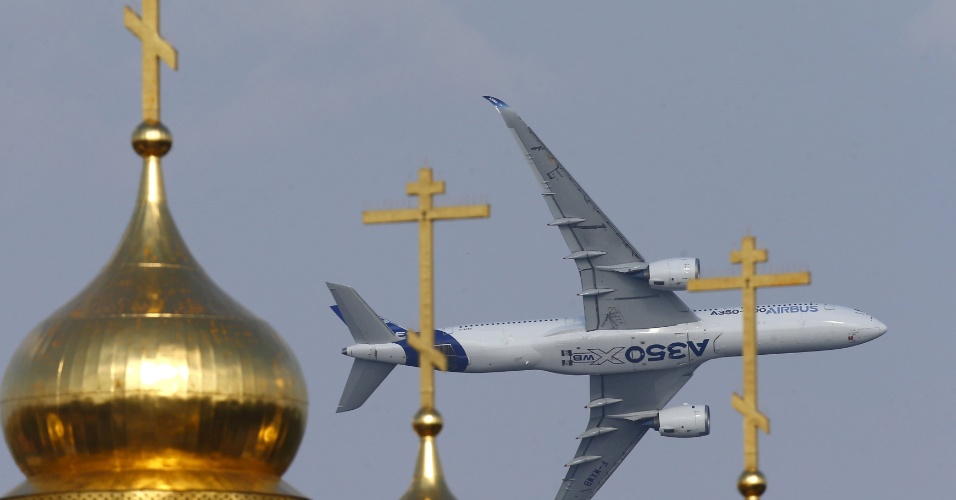 26.ago.2015 - Aeronave Airbus A350 XWB sobrevoa as cúpulas de uma igreja ortodoxa durante o Aviation and Space Salon Internacional MAKS em Zhukovsky, nos arredores de Moscou, na Rússia
