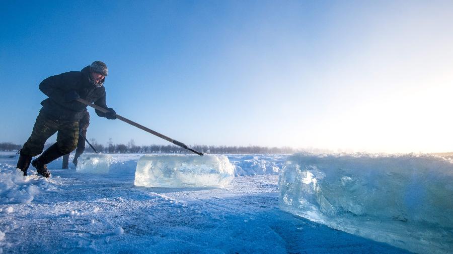 27.nov.2018 - Aldeões cavam gelo de um lago local perto do assentamento de Oi, cerca de 70 km ao sul de Yakutsk, com a temperatura que ficam abaixo 41 graus Celsius - MLADEN ANTONOV/AFP