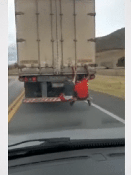 Dois garotos são flagrados pendurados na traseira de caminhão - Reprodução