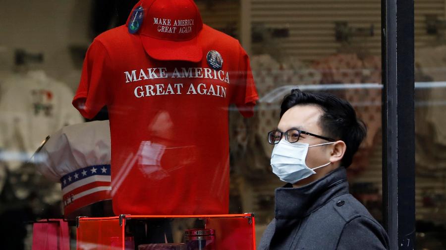 Coronavírus: homem caminha usando máscara em zona de compras de Nova York, nos Estados Unidos - Andrew Kelly/Reuters