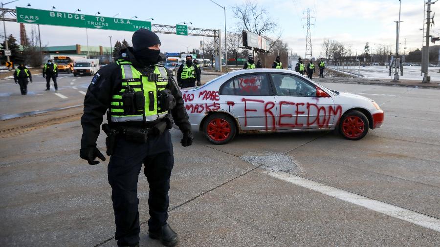 12.fev.2022 - Policiais ficam de guarda na frente de um carro pintado com slogans em protesto, enquanto caminhoneiros e apoiadores continuam bloqueando o acesso à Ambassador Bridge, no Canadá - Carlos Osorio/Reuters