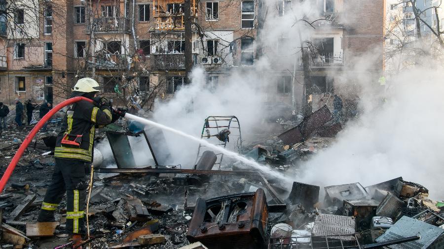 18.mar.2022 - Bombeiro apaga incêndio em local atingido por bombardeio em Kiev, na Ucrânia - REUTERS/Vladyslav Musiienko