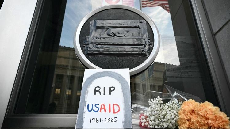 7.fev.2025 - Tributos foram colocados na porta da sede da Usaid após cortes na agência