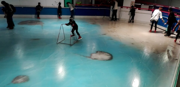 Pessoas utilizam a pista de patinação com 5.000 peixes congelados no Space World - AFP