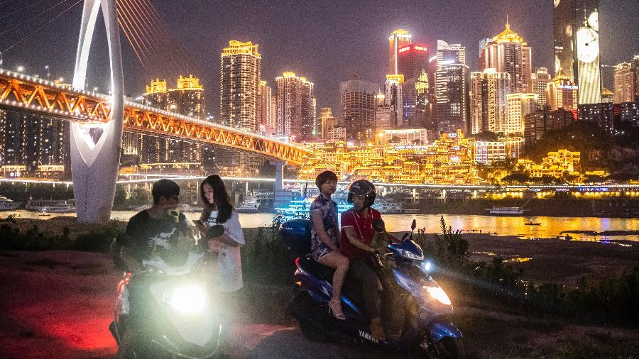 Jovens chineses passeiam perto do rio Yangtze, em Chongqing - Lam Yik Fei/The New York Times