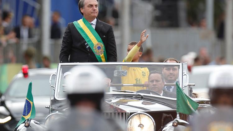 Jair Bolsonaro abre o desfile militar de 7 de Setembro em carro aberto, na Explanada dos Ministérios, em Brasília, ao lado do filho Carlos Bolsonaro e do garoto Ivo César Gonzales - Dida Sampaio/Estadão Conteúdo